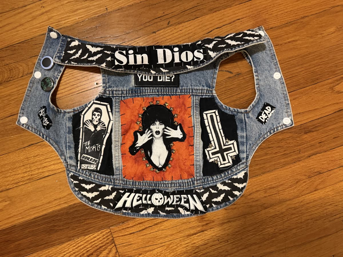 The Elvira vest laid flat: studded Elvira back piece, Misfits coffin patch, cross patch, and Helloween and Sin Dios strips on bat-print fabric