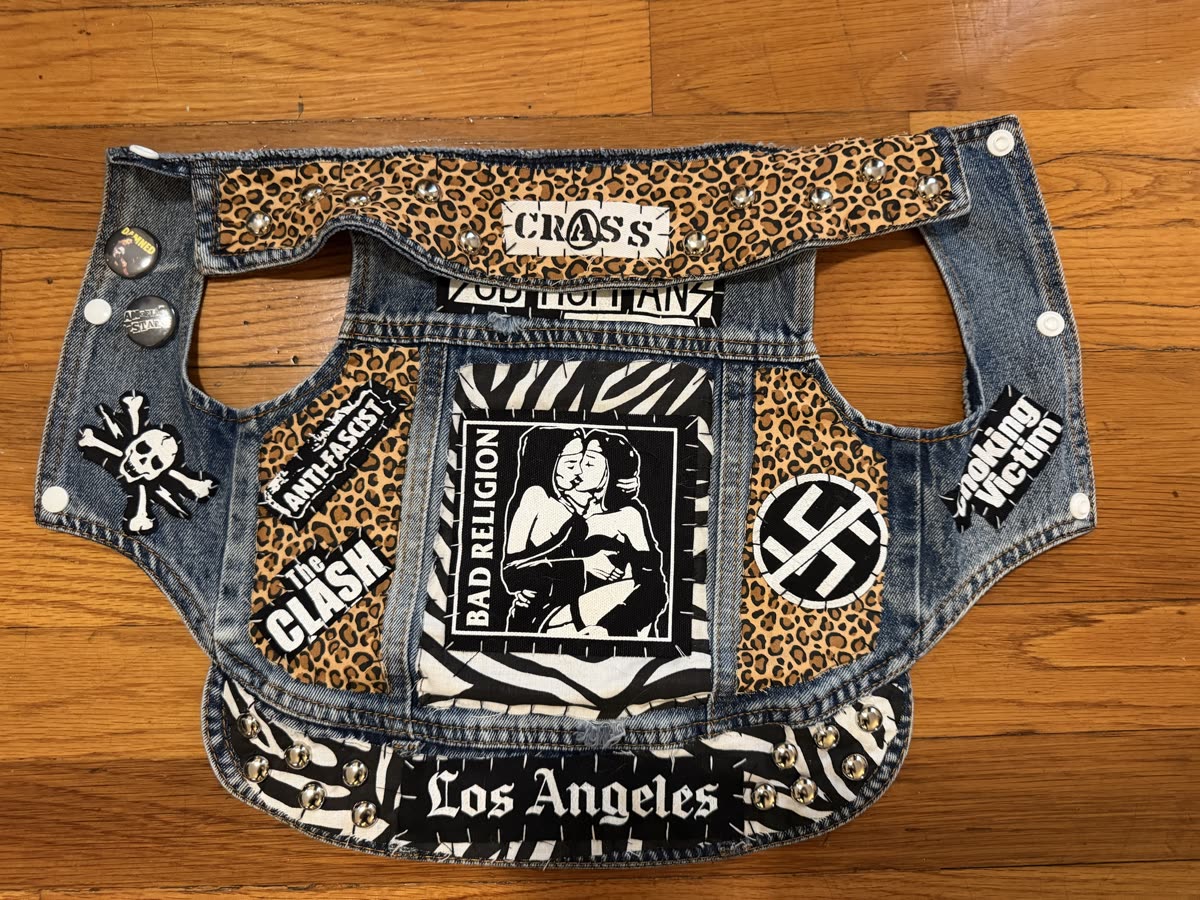 The Protest to Survive vest laid flat: Bad Religion back patch on zebra print, leopard-print panels, The Clash, Anti-Fascist and crossed-out swastika patches, Los Angeles and Crass strips, chrome studs