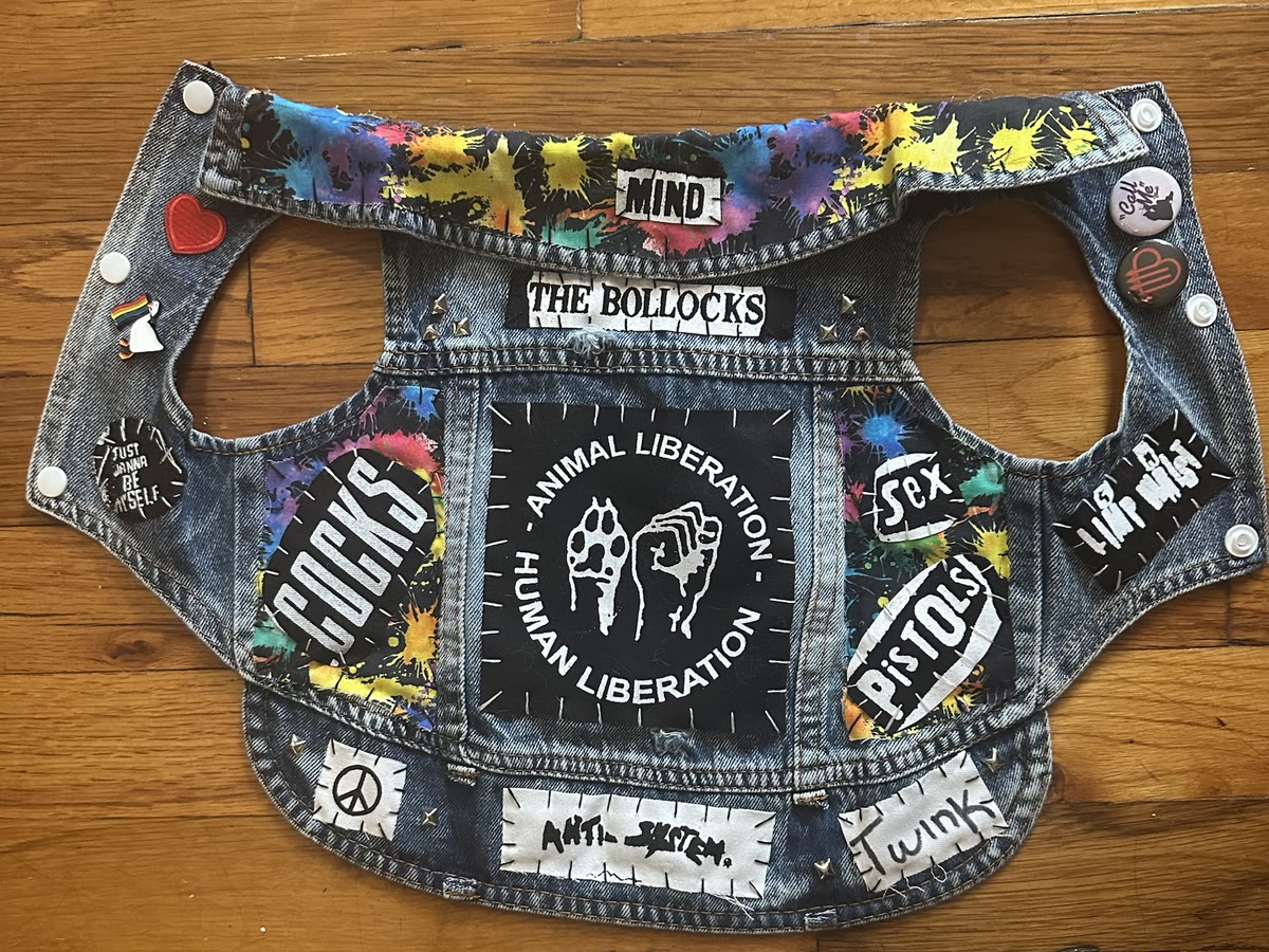 The Pippin vest laid flat: Animal Liberation Human Liberation back patch, paint-splatter collar and side panels, Sex Pistols, Cocks and The Bollocks patches, Peace, Anti-System and Twink strips, studs and pins