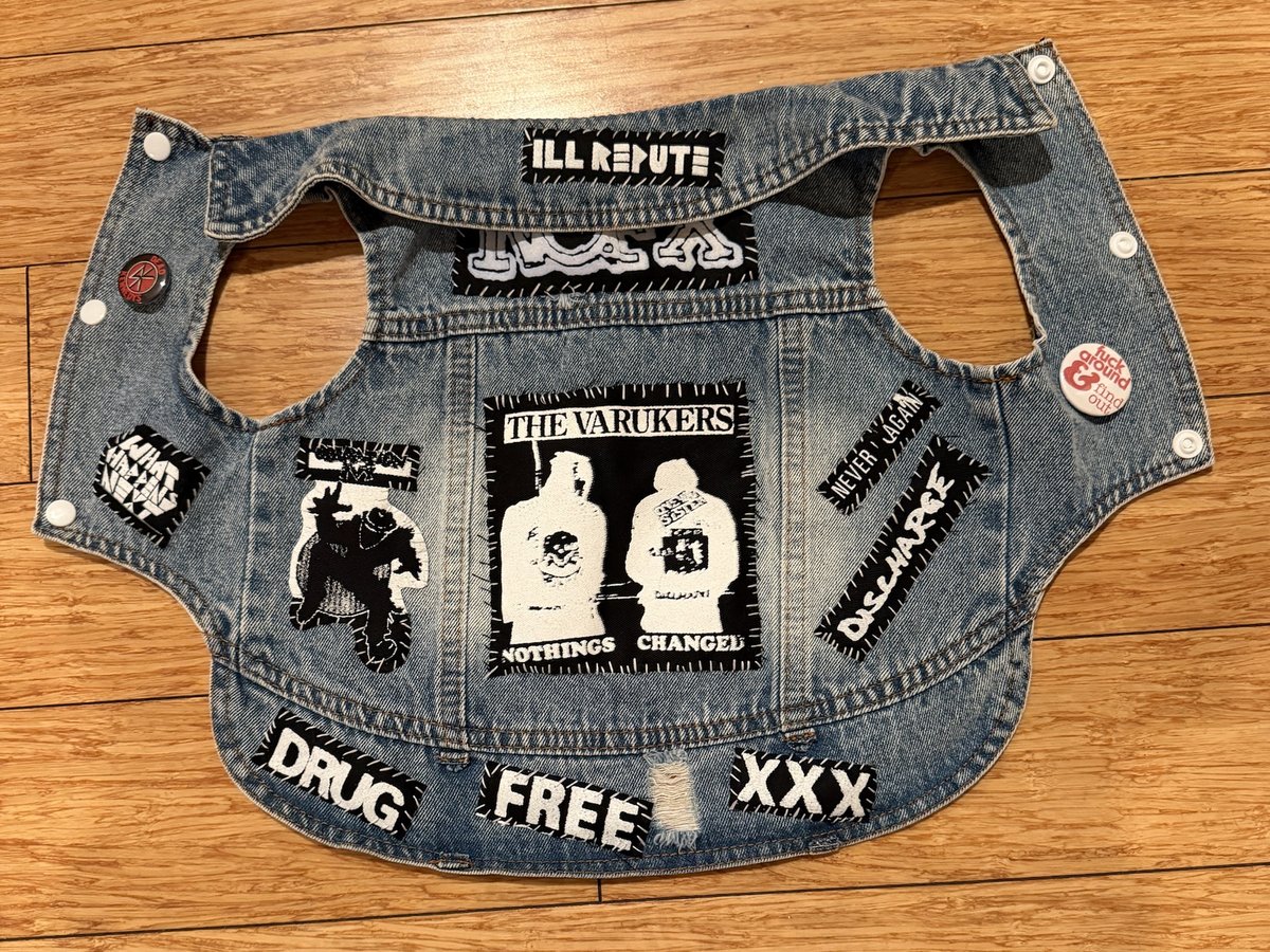 The Ill Repute vest laid flat: light denim with a Varukers Nothings Changed back patch, Ill Repute and NOFX strips at the collar, Discharge and Never Again patches, Drug Free and XXX across the hem, white snaps, a Dead Kennedys pin and a Fuck Around and Find Out button